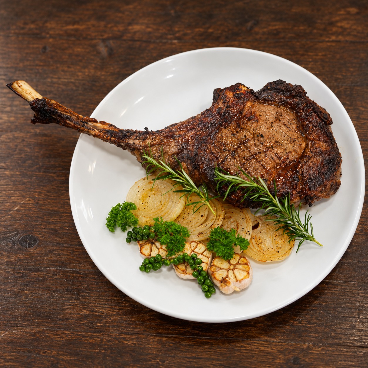 Tomahawk Wagyu MB5+ nguyên phần nhìn từ trên xuống cùng rau thơm và tỏi nướng