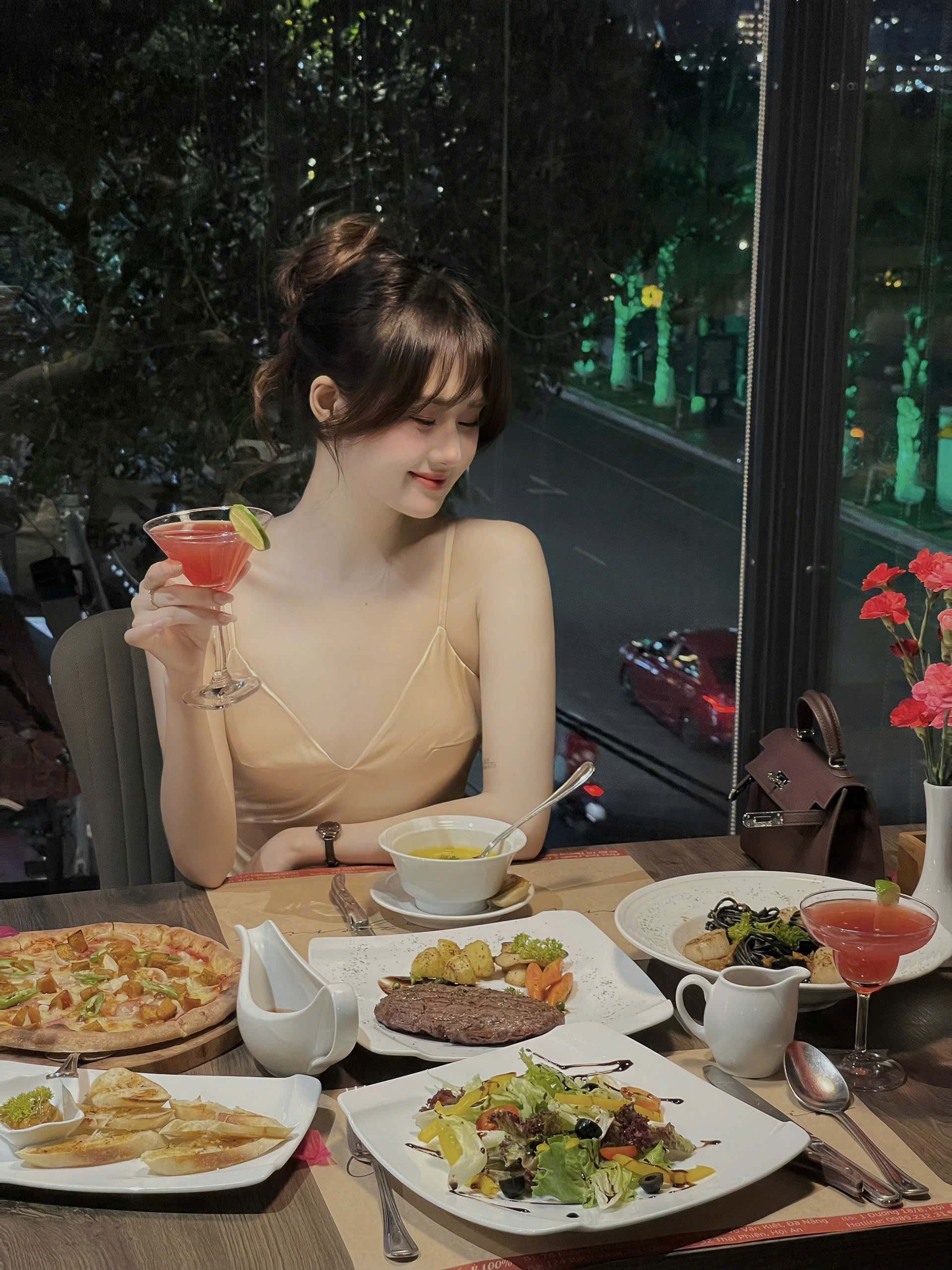Bàn ăn buổi tối tại Cardi Pizzeria Bạch Đằng với pizza, steak, pasta và cocktail
